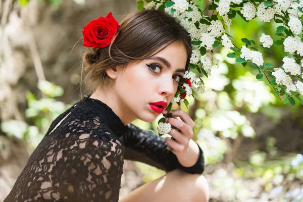 Menina bonito com lábios vermelhos posando com flores brancas florescentes — Fotografia de Stock