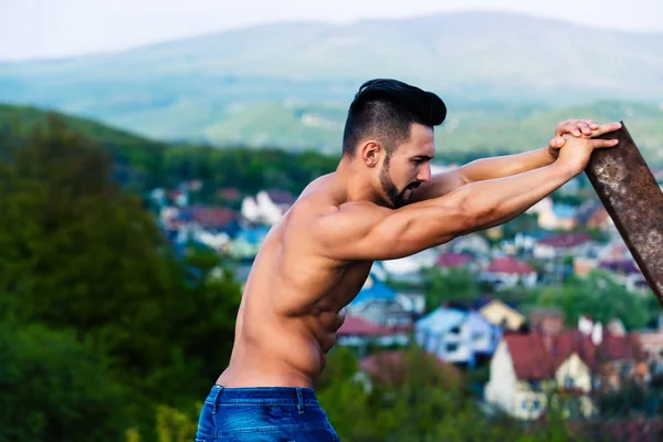 Sexy man z mięśni ciała szkolenia o rod zardzewiały żelazo — Zdjęcie stockowe