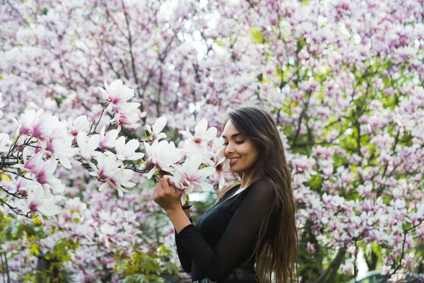 Outdoor portrait of a young beautiful woman near magnolia tree — Stock Photo, Image