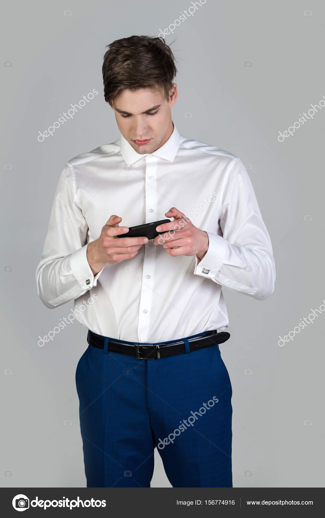 Homme en chemise blanche pantalon bleu avec telephone a boutons de manchette Photo de stock par Tverdohlib 156774916