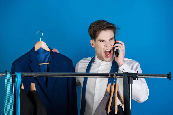 Бізнесмен на вішалці з телефоном, кричить сердитий чоловік — стокове фото
