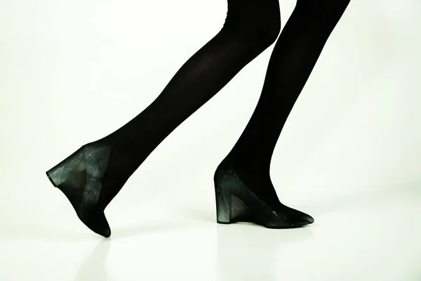 Boty a černé punčochy na štíhlé nohy dívky — Stock fotografie