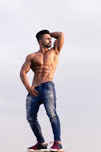 Macho guy with muscular body in sunglasses on blue sky — Stock Photo, Image