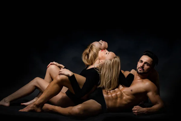 Hombre con cuerpo muscular con chicas gemelas — Foto de Stock