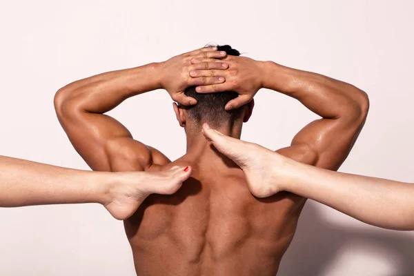 torso of muscular man with raised hands and female legs