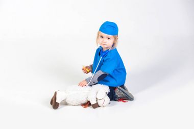 Doktor veteriner oyuncak hayvan ile oynarken üniforma içinde küçük çocuk