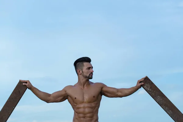 Hombre con el entrenamiento muscular en la barra de hierro oxidado — Foto de Stock