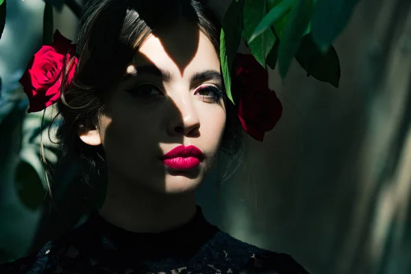 Красива дівчина з червоними губами і трояндами в брюнетці волосся — стокове фото