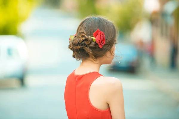 Vue arrière de la femme avec des roses rouges dans les cheveux élégants — Photo