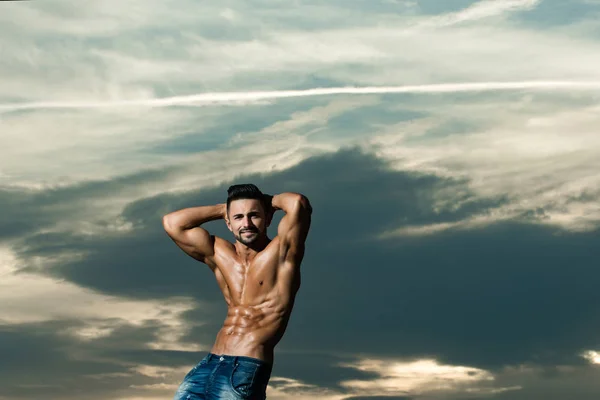 Homem com corpo muscular no céu azul — Fotografia de Stock