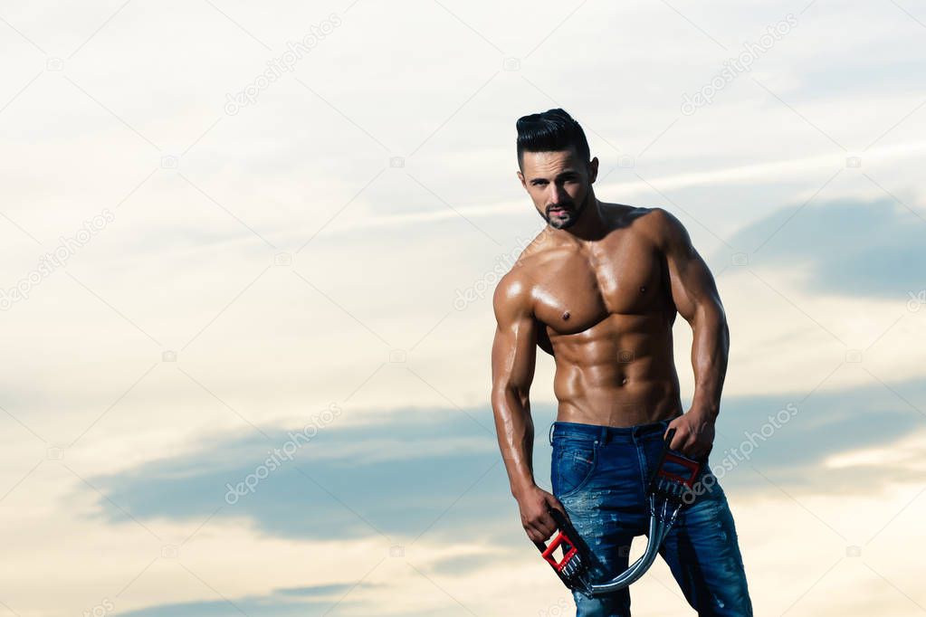 sexy man with muscular body workout with expander gripper