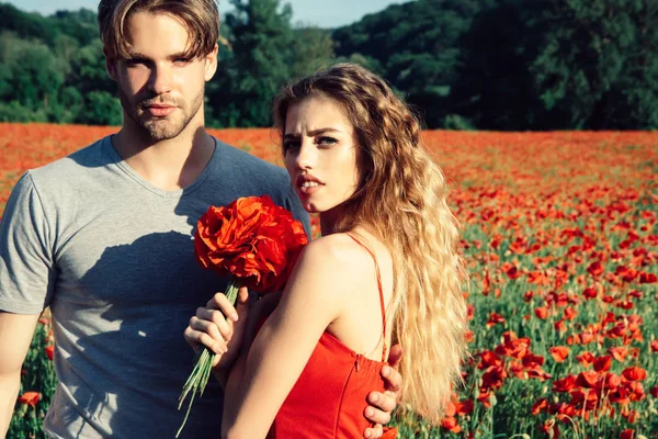 Bărbat și fată cu buchet de flori în câmp de mac roșu — Fotografie, imagine de stoc