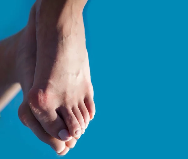 Bone on foot toe reflecting in mirror on blue — Stock Photo, Image