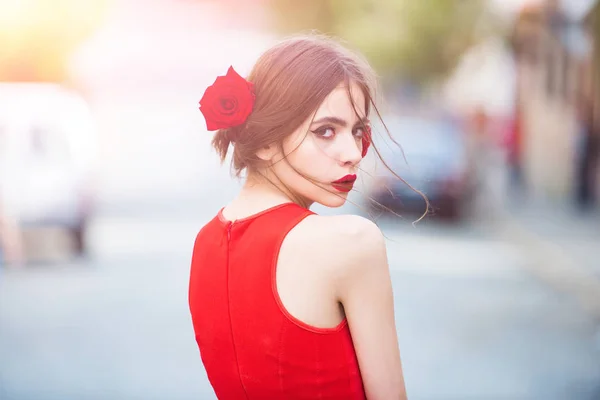 머리에 장미와 함께 밝은 빨간 드레스 유행 여자 — 스톡 사진