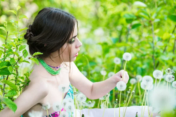Menina com maquiagem elegante e contas em folhas verdes — Fotografia de Stock