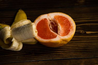 penis and vagina, banana with yellow peel in red grapefruit