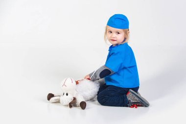 Doktor veteriner oyuncak hayvan ile oynarken üniforma içinde küçük çocuk