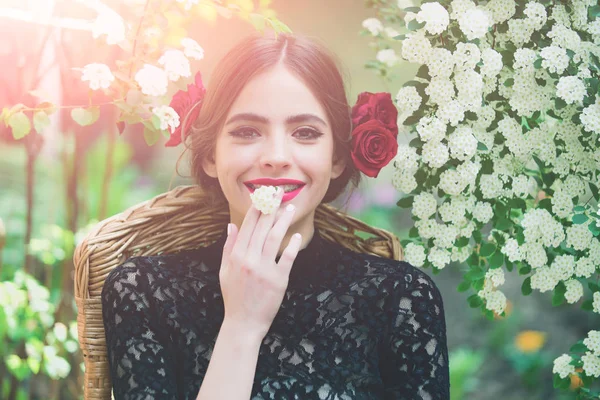 Девушка улыбается с белым цветком во рту — стоковое фото
