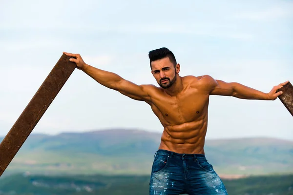 Hombre con el entrenamiento muscular en la barra de hierro oxidado — Foto de Stock