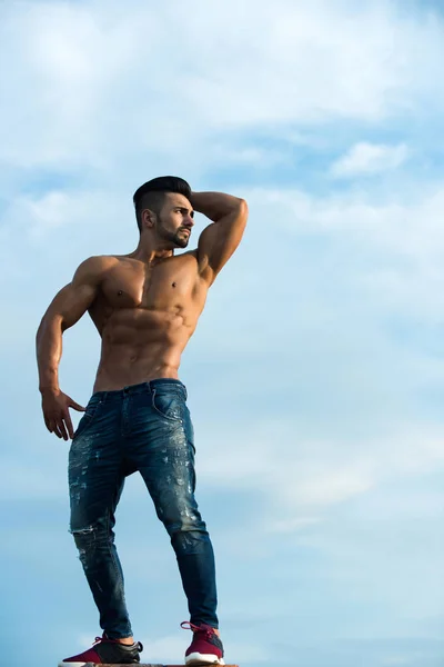 Macho man with muscular body on blue sky — Stock Photo, Image