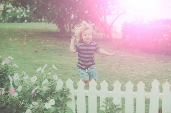 Gyermek vagy kisfiú nyitott fehér fából készült kerítés közelében — Stock Fotó