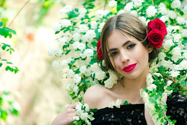 Genç güzel kadın saç modeli, makyaj ve kırmızı çiçekli — Stok fotoğraf