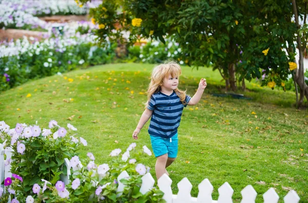 Jongen of klein kind buiten in de buurt van witte houten hek — Stockfoto