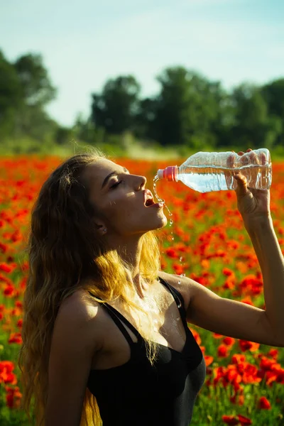 Meisje op gebied van maanzaad water drinken uit de fles — Stockfoto