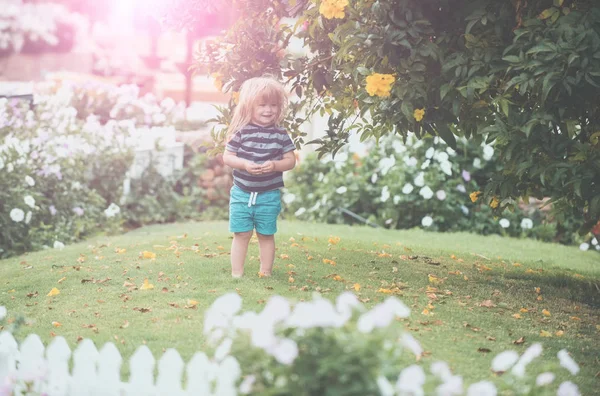 Baby oder glücklicher kleiner Junge im Freien in der Nähe von weißem Holzzaun — Stockfoto