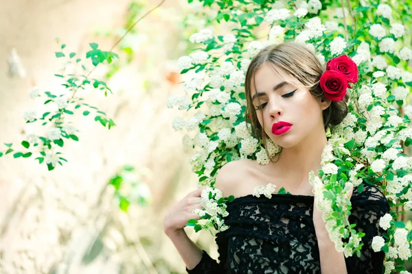 Ung vacker kvinna med makeup och röd blomma i frisyr — Stockfoto