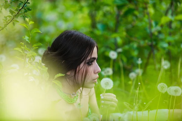 Menina com maquiagem elegante e contas em folhas verdes — Fotografia de Stock