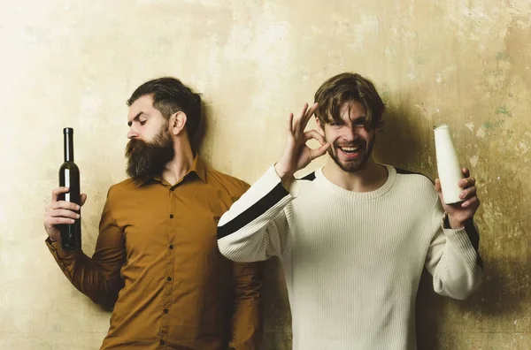 Hipster mirando botella de vino y hombre feliz con yogur — Foto de Stock