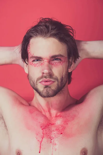 Jongen of man met creatieve modieus make-up op rode achtergrond — Stockfoto