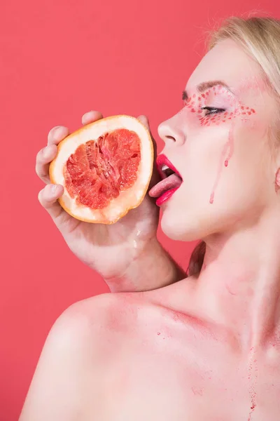 Vrouw met creatieve modieuze make-up lick grapefruit, vitamine — Stockfoto