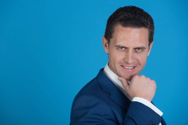 mavi arka plan üzerinde mutlu gülümseyen iş adamı