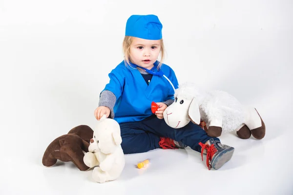 Niño pequeño niño trabaja médico o veterinario con juguete — Foto de Stock