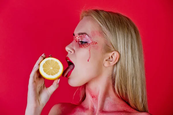 Frau mit kreativem modischem Make-up lecken Zitrone, Vitamin — Stockfoto