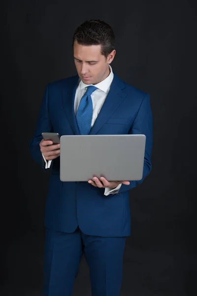 Biznesmen przy użyciu telefonu komórkowego podczas pracy na laptopie — Zdjęcie stockowe