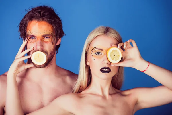 couple of woman and man with makeup hold lemon