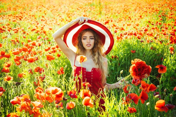 Schönes Mädchen mit Hut im roten Mohnfeld — Stockfoto