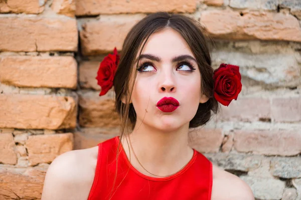 Kvinna med röda läppar och färska rosor i håret — Stockfoto