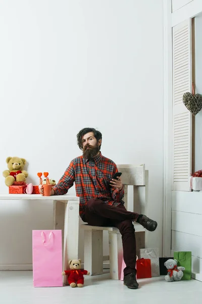 Homme barbu avec smartphone et tasse assis sur la chaise — Photo