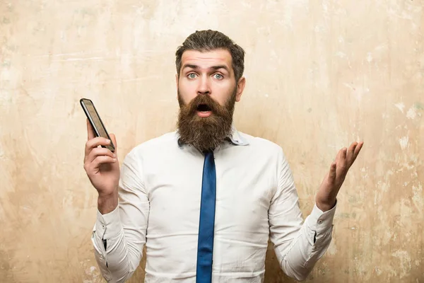Hombre o hipster con barba larga mantenga el teléfono móvil — Foto de Stock
