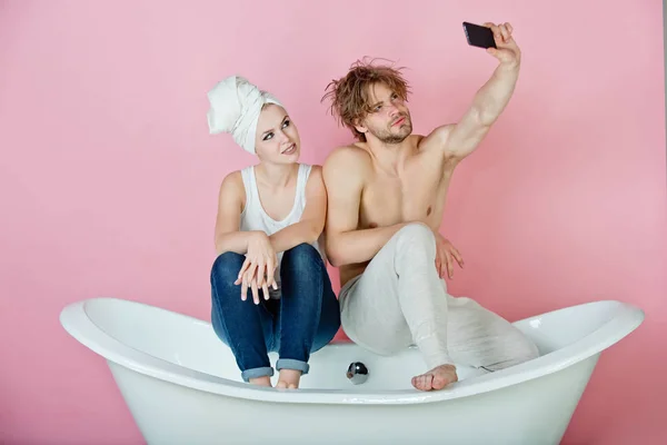 Homme et femme sur baignoire avec téléphone, couple amoureux — Photo
