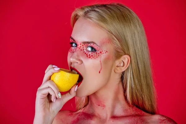 Frau mit kreativem modischen Make-up beißen Zitrone, Vitamin — Stockfoto