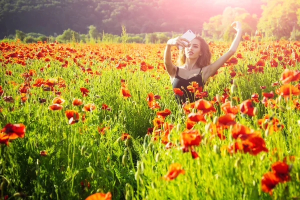 ケシ畑の少女の携帯電話で selfie 写真 — ストック写真