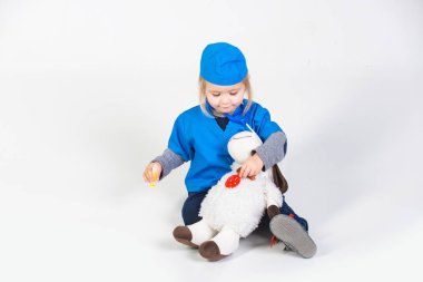 Doktor veteriner oyuncak hayvan ile oynarken üniforma içinde küçük çocuk