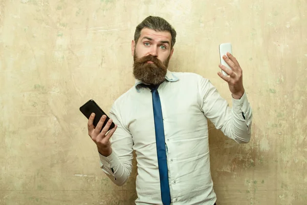 Homem ou hipster comparar telefone celular e smartphone — Fotografia de Stock