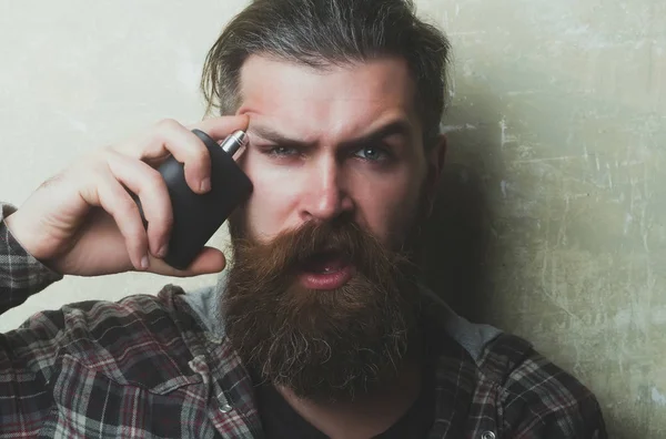 Parfüm yüzü açık ağız ile uygulayarak şaşırmış sakallı adam