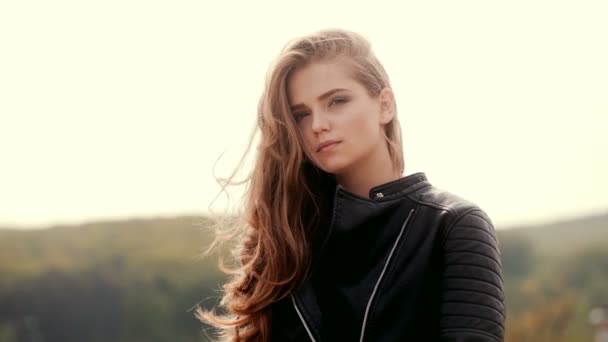 Blonde Girl With Wavy Hair In Black Jacket Against The Background